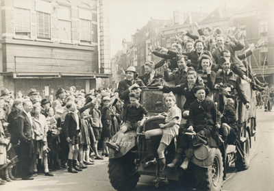 879262 Afbeelding van een vrachtwagen volgeladen met feestvierende burgers, tijdens de intocht van de geallieerden op ...